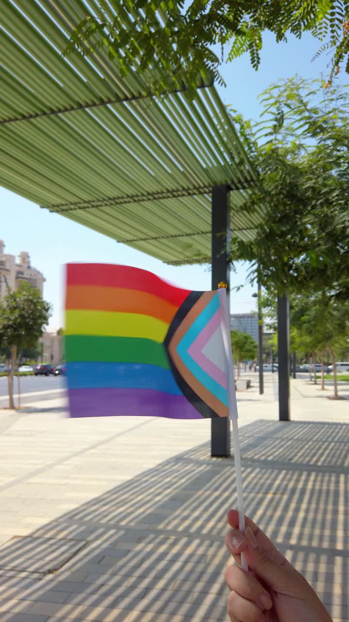 Progress pride flag waving in urban setting
