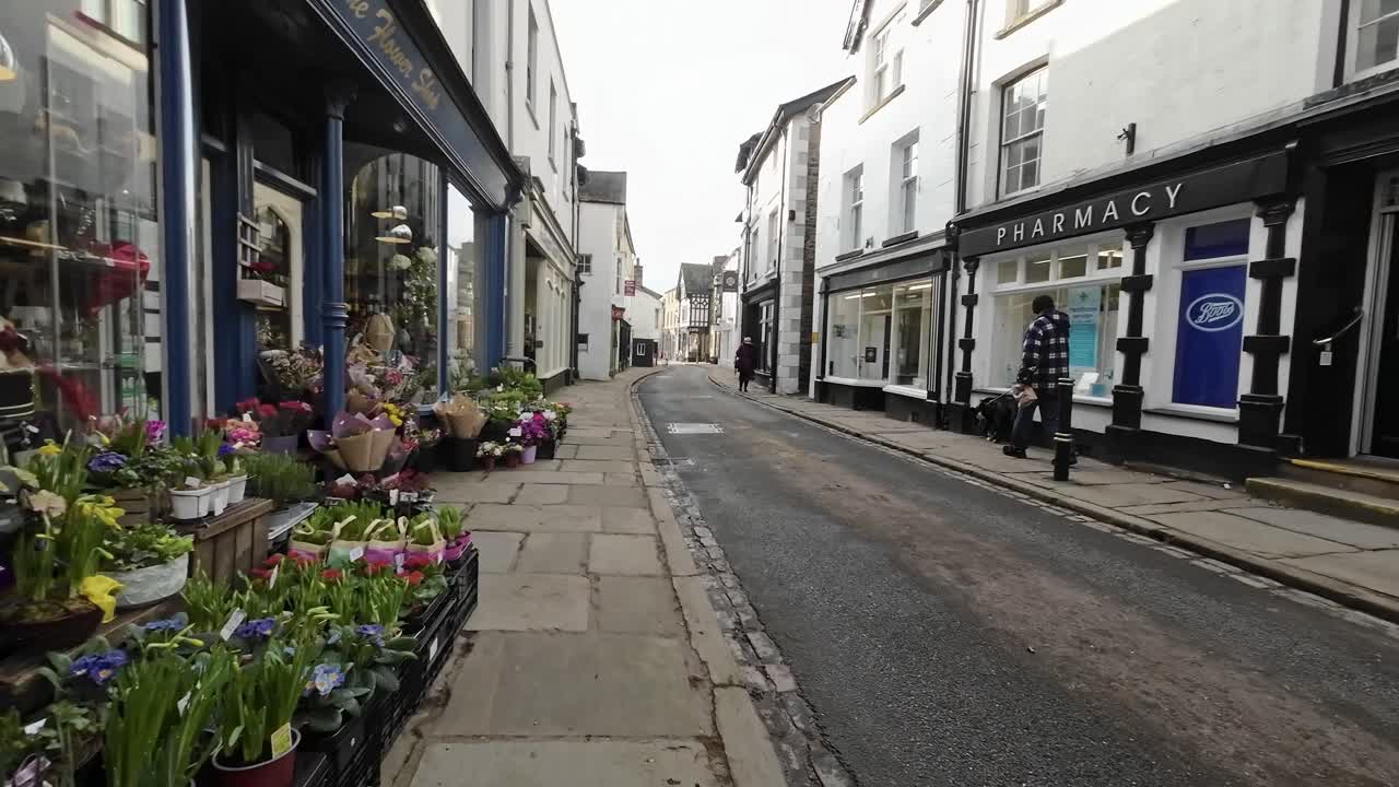 Editorial footage of the Cumbrian Village of Sedbergh in the English Lake District. Showing traffic and tourists walking and shopping