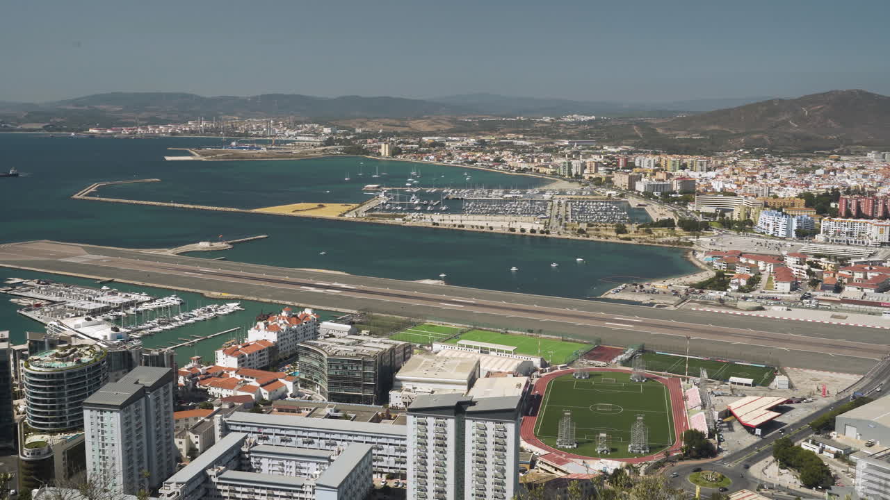 puerto de la ciudad de la bahía de gibraltar y pista del aeropuerto que se extiende hasta el mar