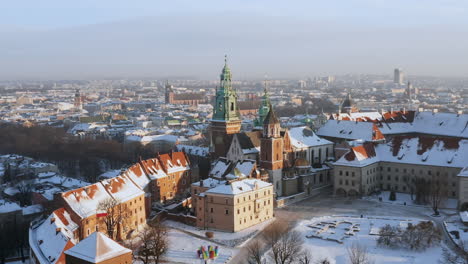 panorama del castillo de wawel cubierto de nieve y el casco antiguo en la mañana mágica con la suave luz del sol durante el invierno, cracovia, polonia