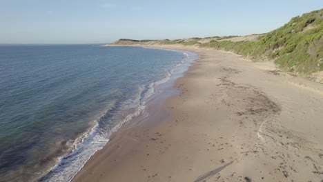 Frau-Wirft-Etwas-Aus-Dem-Sand-In-Die-Luft-Am-Strand-Auf-Phillip-Island-In-Victoria,-Australien