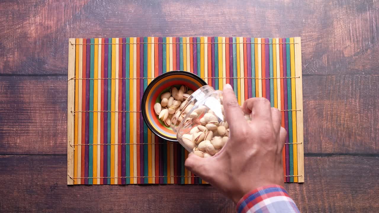 vertiendo los pistachos a mano en un cuenco