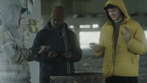 homeless men huddling for warmth around a barrel