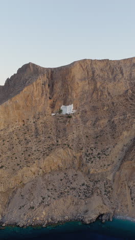 aerial view of panagia hozoviotissa monastery, nestled into towering cliffs, amorgos, greece. vertical