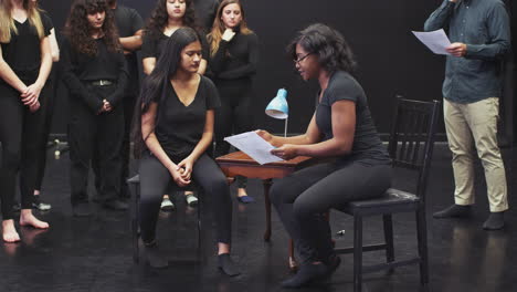 teacher with drama students at performing arts school in studio improvisation class