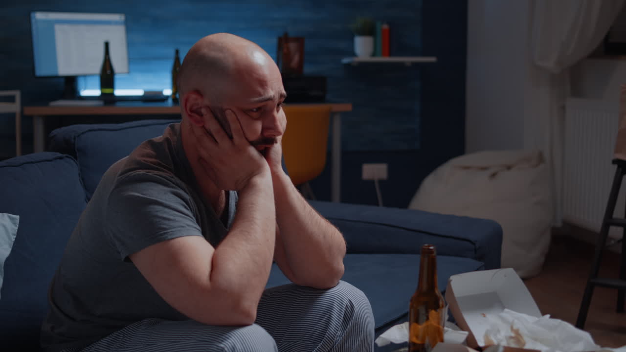 Psychotic alone depressed man sitting in sofa feeling disappointed