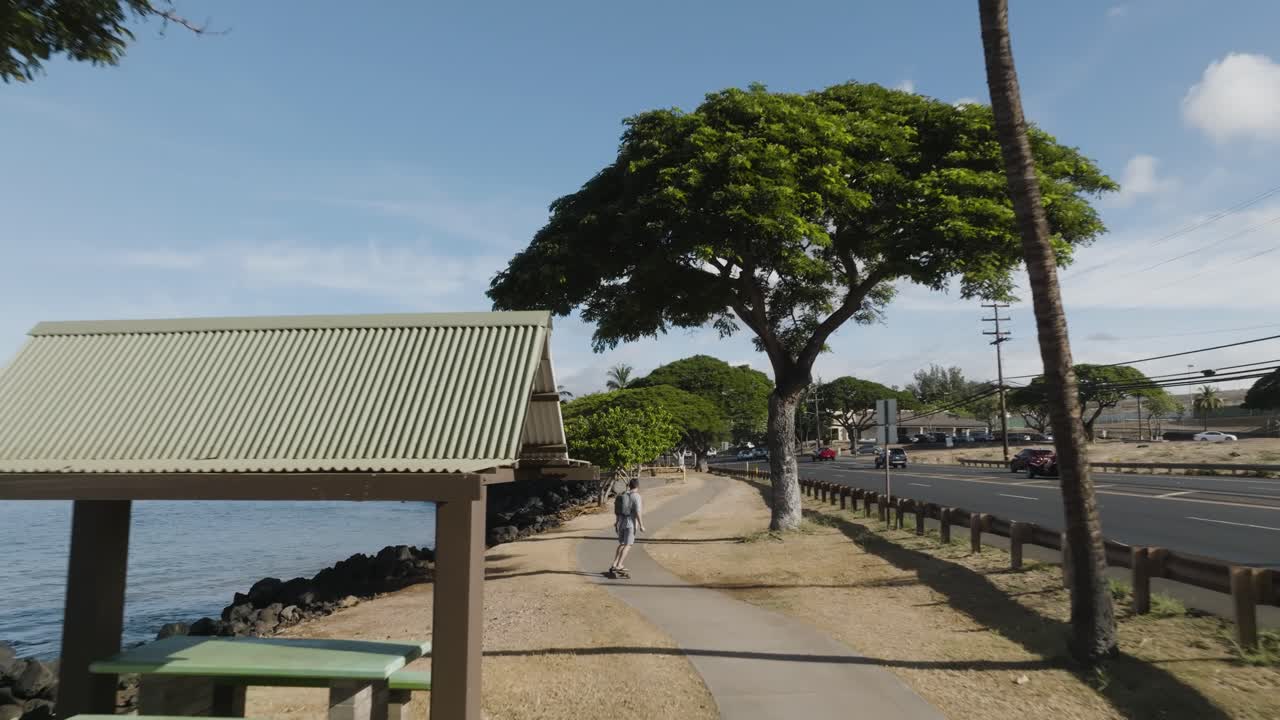 미국 마우이 라하이나의 경치 좋은 해변 산책로를 따라 남자 전기 스케이트보드