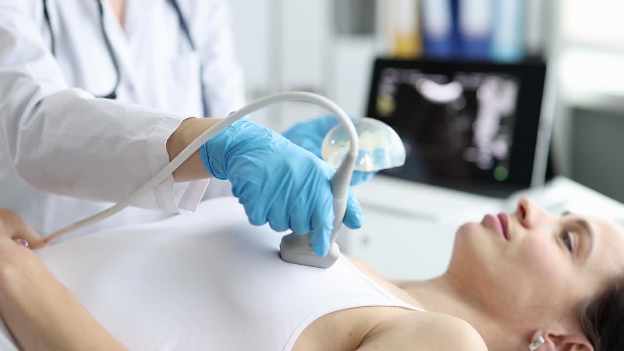 Medico che usa una macchina ecografica per esaminare il torace e il cuore di una donna