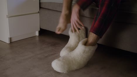 el hombre se pone las pantuflas por la mañana