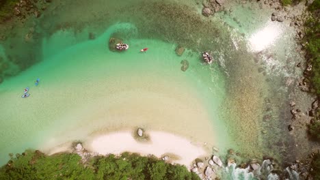 vista aérea de personas haciendo rafting rodeadas de rocas en el río soca, eslovenia.
