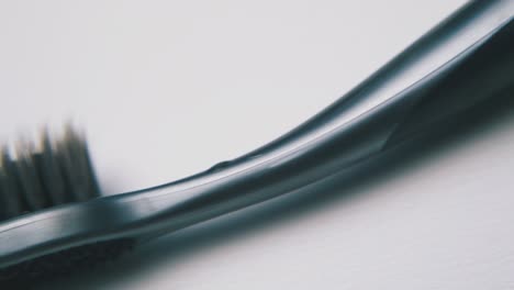 toothbrush with black bristles on white background macro