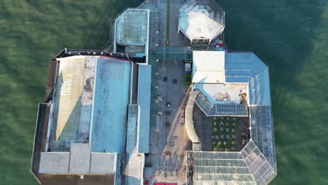 Aerial-drone-flight-showing-a-birdseye-view-over-the-amusements-promenade-in-Blackpool-with-a-rippling-green-ocean