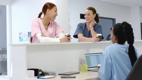 diverse doctors talking to medical recepcionist sitting at front desk at hospital, slow motion