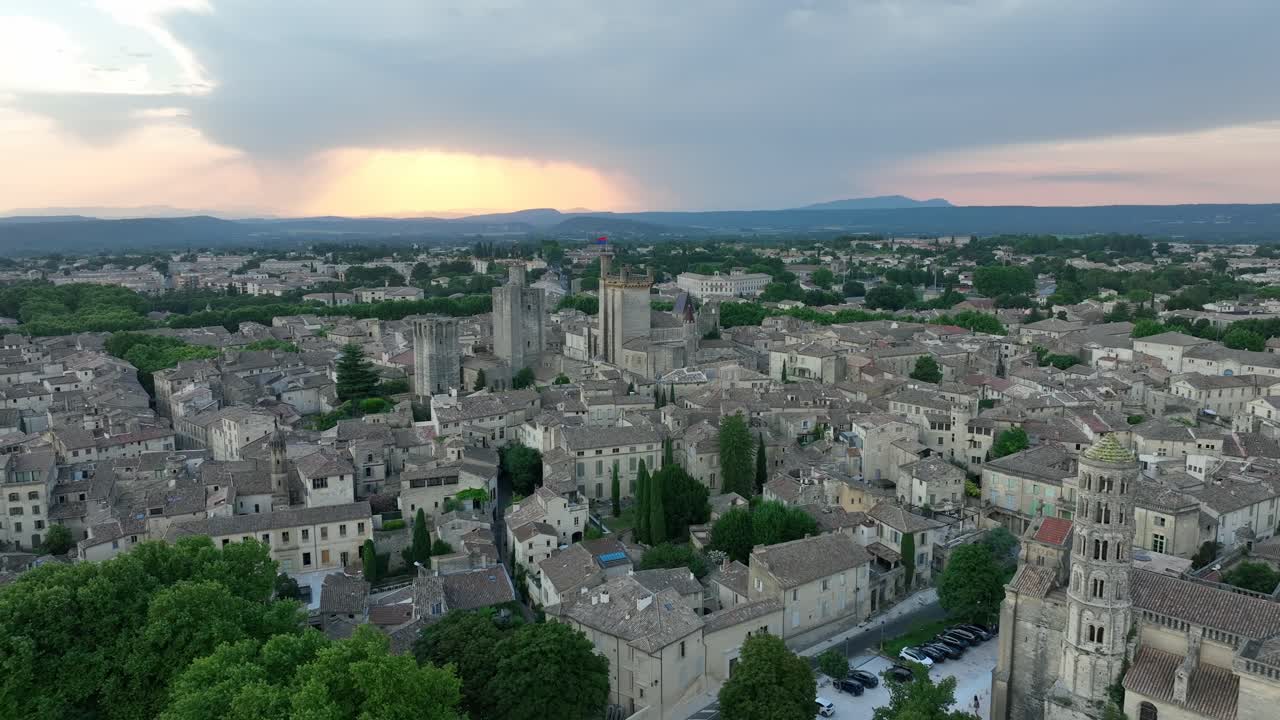 Aerial flying backwards from fortified castle in medieval town of Uzes, France