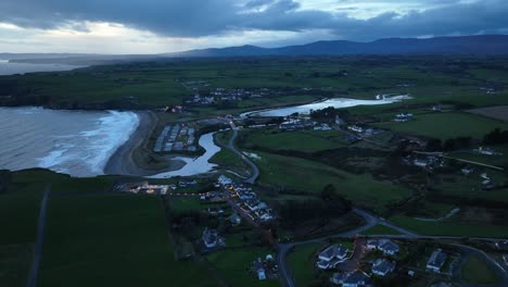 Night-drone-approach-cinematic-Bunmahon-Village-Copper-Coast-Waterford-Ireland-on-a-winter-evening-with-new-Coast-guard-station