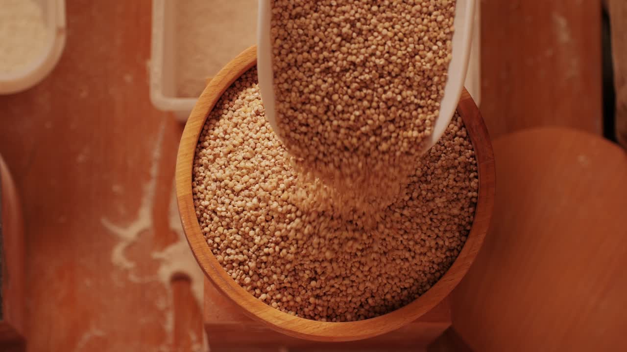 Close-up shot of treatment of seeds of cereals: rye, barley, wheat against diseases and insects using modern equipment. Hard wheat in hopper being ground into whole wheat flour. High quality 4k footage