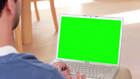 Over-shoulder-view-of-casual-man-using-laptop