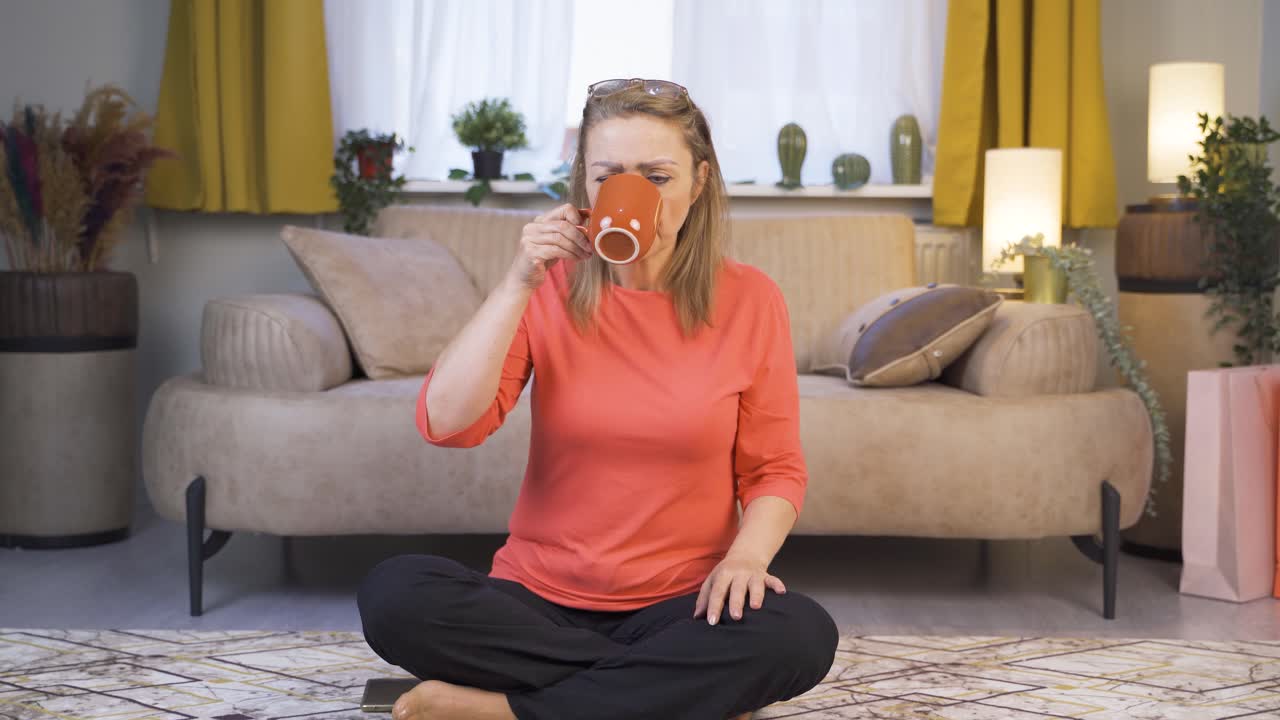 The woman's mouth is burning from the hot drink.