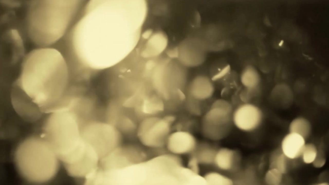 Abstract Golden Light Bokeh Particles Floating in Dark Background