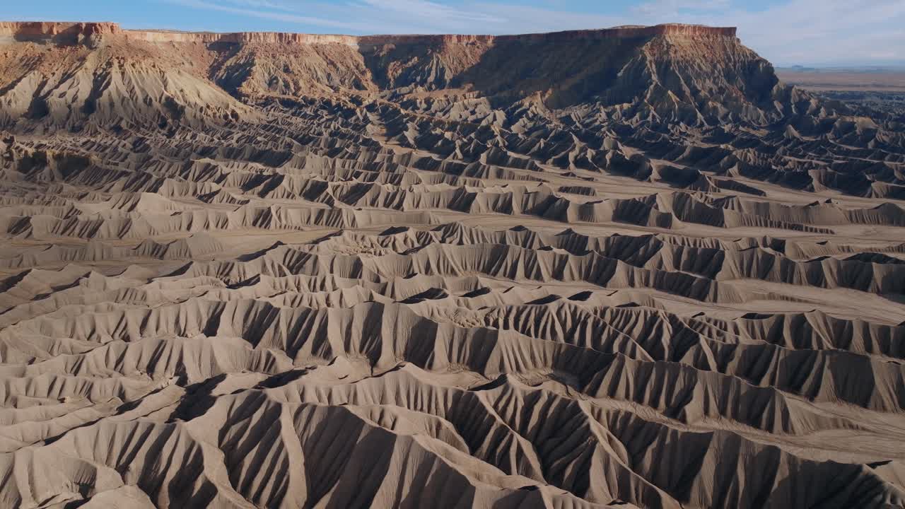 Strukturierte Wüsten-Badlands-Gräte bilden sich wiederholende Erosionsmuster in Utah nahe Factory Butte, Drohnenaufnahme