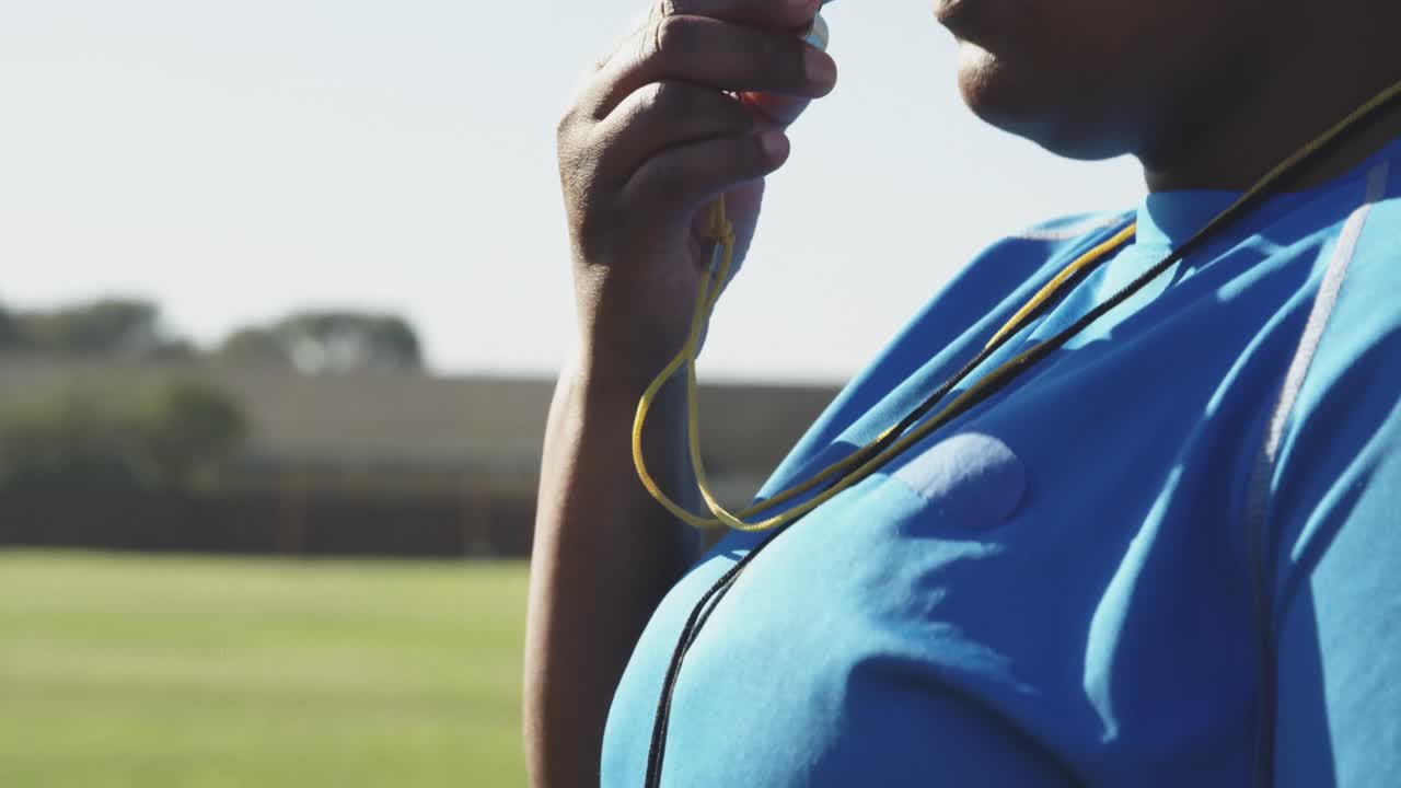 entrenadora de rugby soplando el silbato