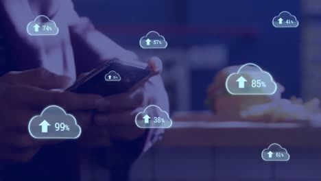 animación de iconos de nubes con un porcentaje creciente contra la sección media del hombre que utiliza el teléfono inteligente.
