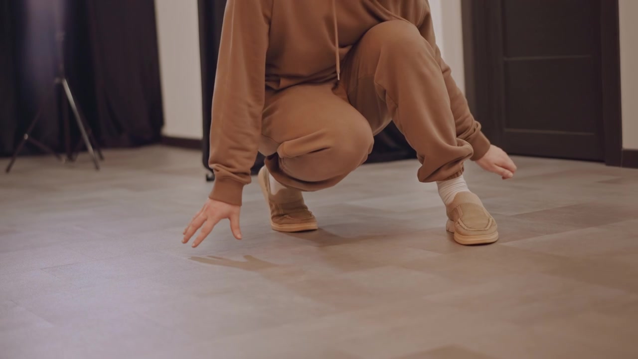 White dancer practicing precise footwork on studio floor, closeup feet and sneakers, controlled heel and toe technique, partner moving into frame, timing and sync emphasized, parquet reflections