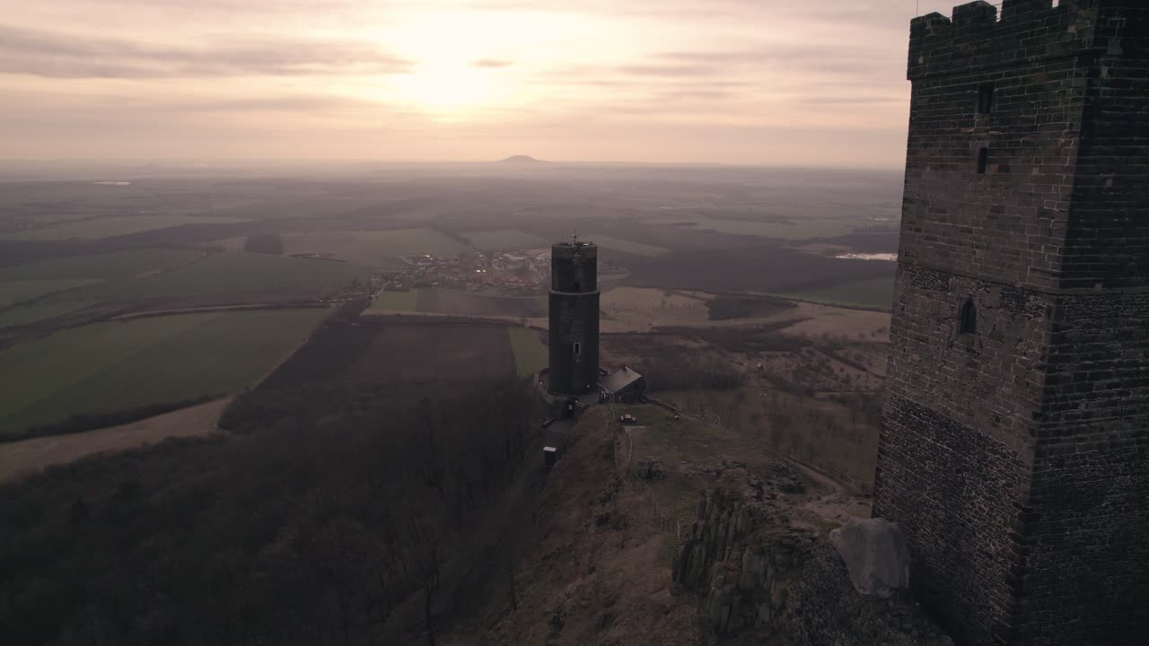 sobrevuelo de avión no tripulado de bajo nivel, majestuosa cima de la montaña torre del castillo medieval al anochecer