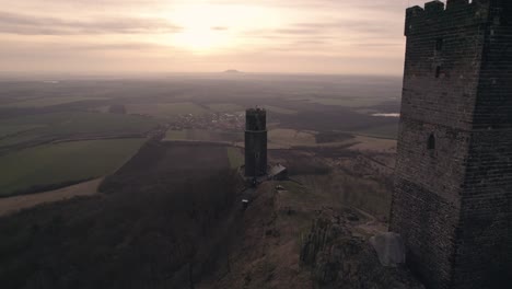 Sobrevuelo-De-Drones-De-Bajo-Nivel,-Majestuosa-Torre-Del-Castillo-Medieval-En-La-Cima-De-Una-Montaña-Al-Atardecer