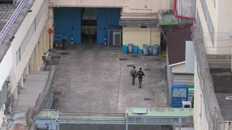 un vehículo policial llega al centro de recepción correccional masculino lai chi kok mientras los guardias penitenciarios aseguran el área en hong kong