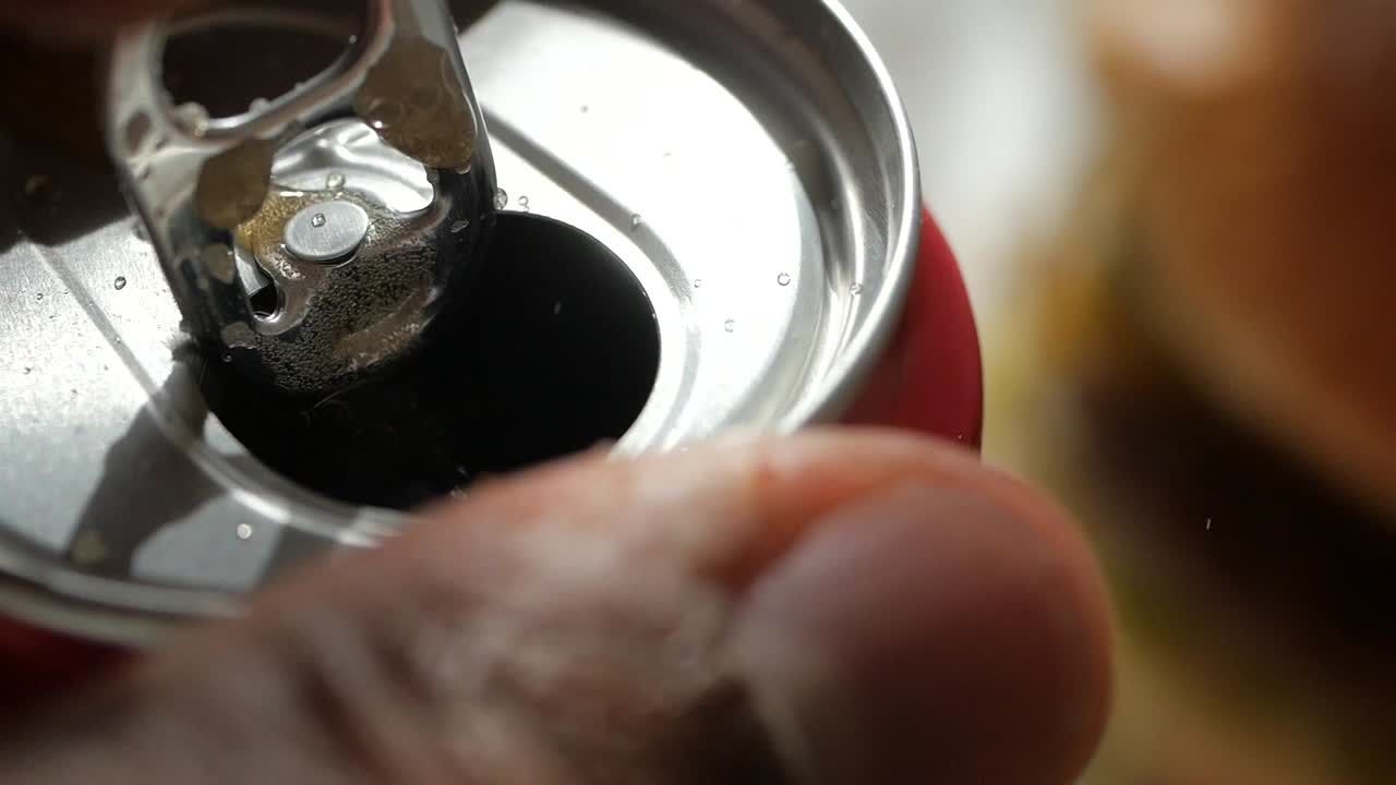 Apertura di una lattina di bibita rossa