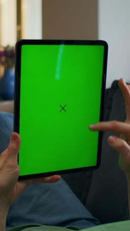 persona sosteniendo una tableta con una pantalla verde y una x