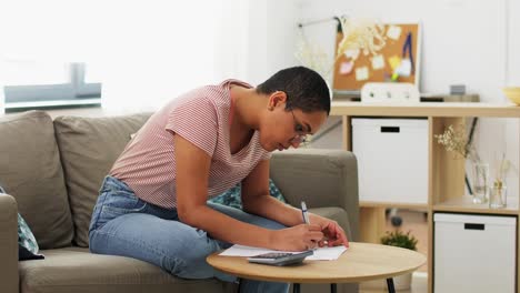 Primer-Plano-De-Una-Mujer-Africana-Haciendo-Cálculos-En-Una-Calculadora-De-Papel.-Primer-Plano-De-Una-Mujer-Africana-Haciendo-Cálculos-En-Una-Calculadora-De-Papel.