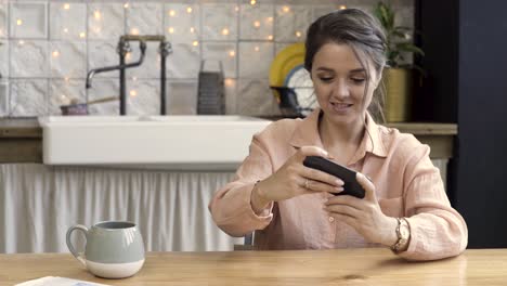 woman using phone in kitchen