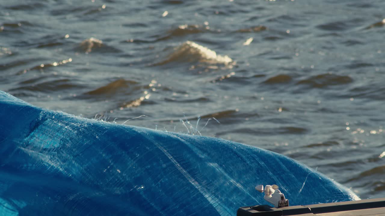 강가에서 너덜너덜한 돛이 바람에 펄럭인다