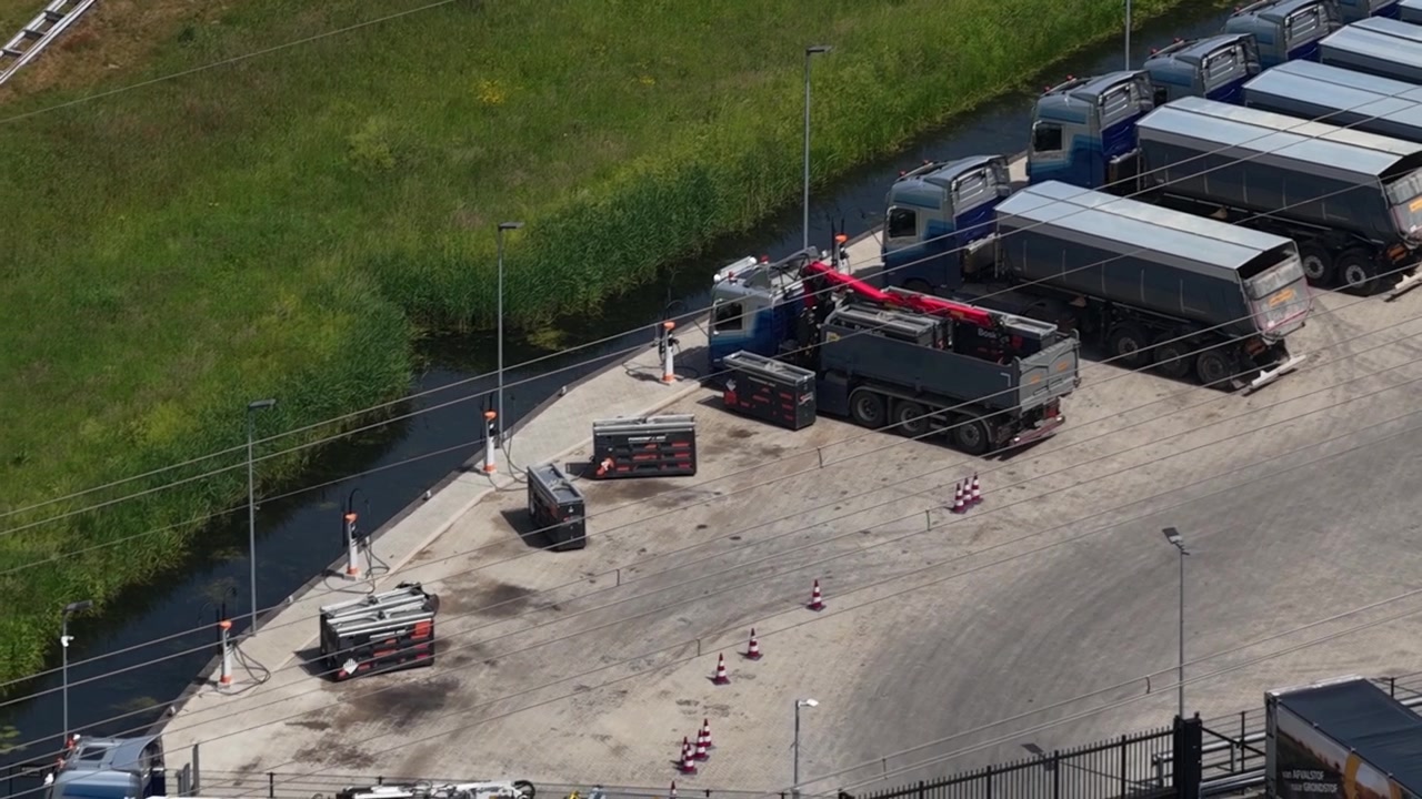 Aerial view of electric trucks with mobile battery units used for charging vehicles in the field, showing fleet electrification, energy storage and sustainable transport technology.