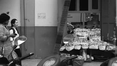 street scene in a city: people walking past a street vendor