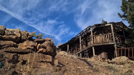 Altes-Verlassenes-Rustikales-Holzhaus-Aus-Dem-Amerikanischen-Wilden-Westen-An-Einem-Sonnigen-Tag,-Panorama-Aus-Niedrigem-Winkel