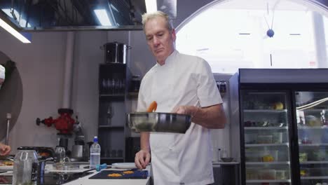 Chef-Masculino-Caucásico-Profesional-En-La-Cocina-De-Un-Restaurante-Preparando-Comida-Usando-Una-Sartén