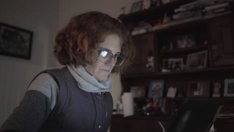 Close-view-of-a-redhead-woman-writing-on-her-laptop-at-home