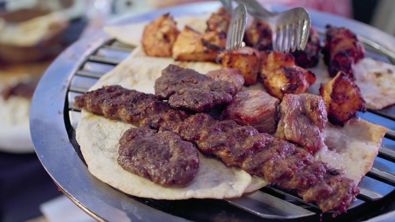 Carni grigliate assortite e piadina su una griglia di metallo