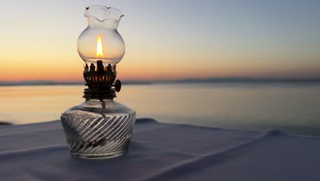 lámpara de aceite de mesa vintage contra el telón de fondo de la puesta de sol