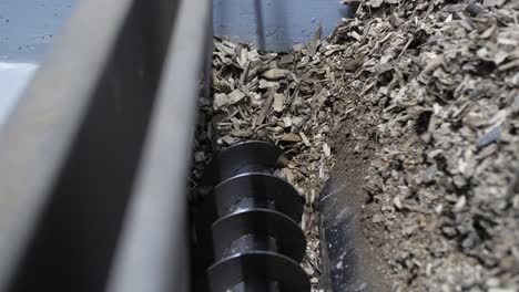 wood chips in a hopper moving into a boiler that burns biomass, slow motion