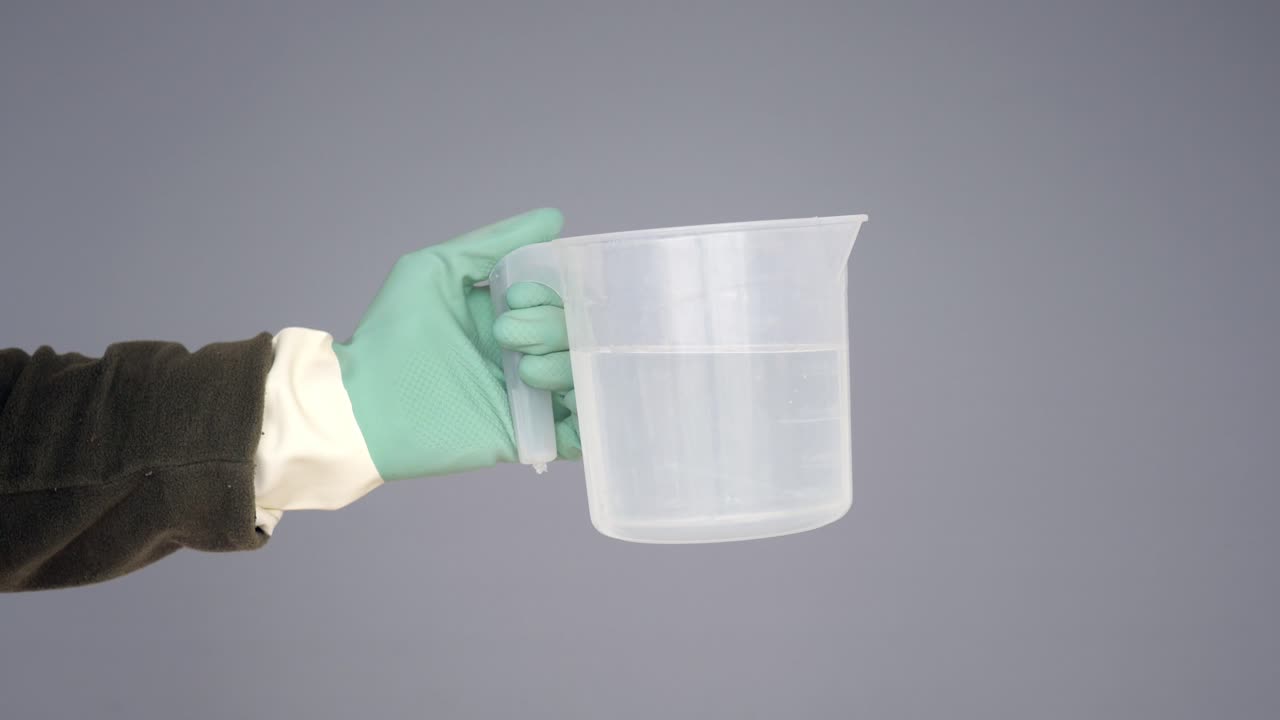 물 으로 가득 찬 측정 컵 을 들고 있는 손