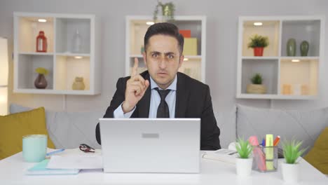 home office worker man looking at camera with a stern angry warning.