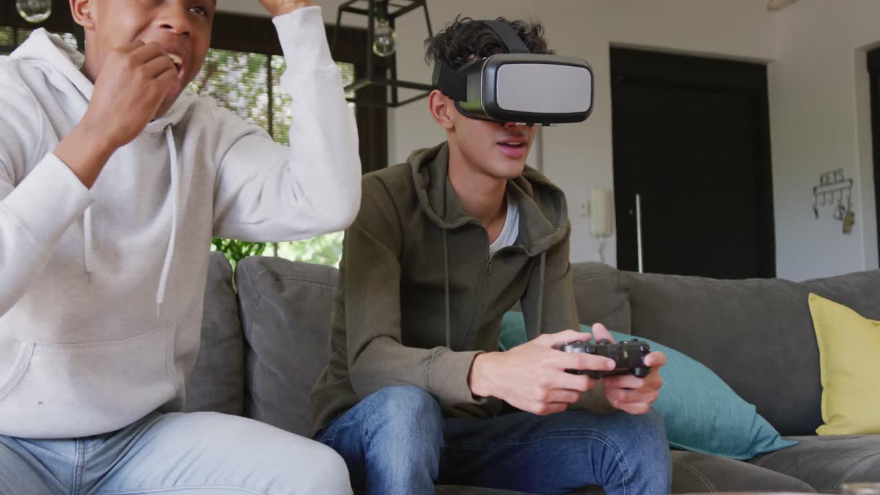 Felici amici adolescenti multietnici che giocano ai videogiochi e usano visori VR a casa, al rallentatore