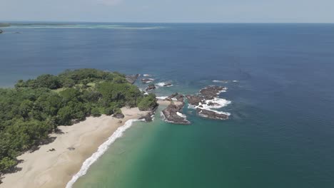 Aerial-panorama-of-Tobago's-stunning-white-sand-and-crystal-clear-coastline-in-the-Caribbean-with-blue-skies-in-the-background