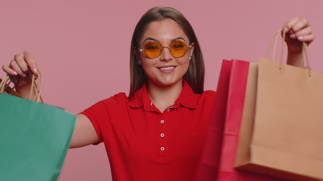 행복 한 관광객 여성 이 쇼핑 가방 을 보여 주고, 휴일 할인 을 광고 하고, 낮은 가격 에 놀랐다