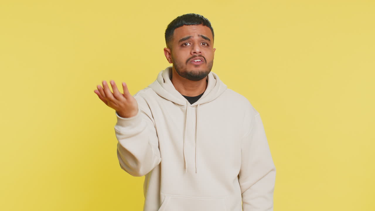 Indian man trying hear you looking confused and frowning keeping arm near ear for louder voice