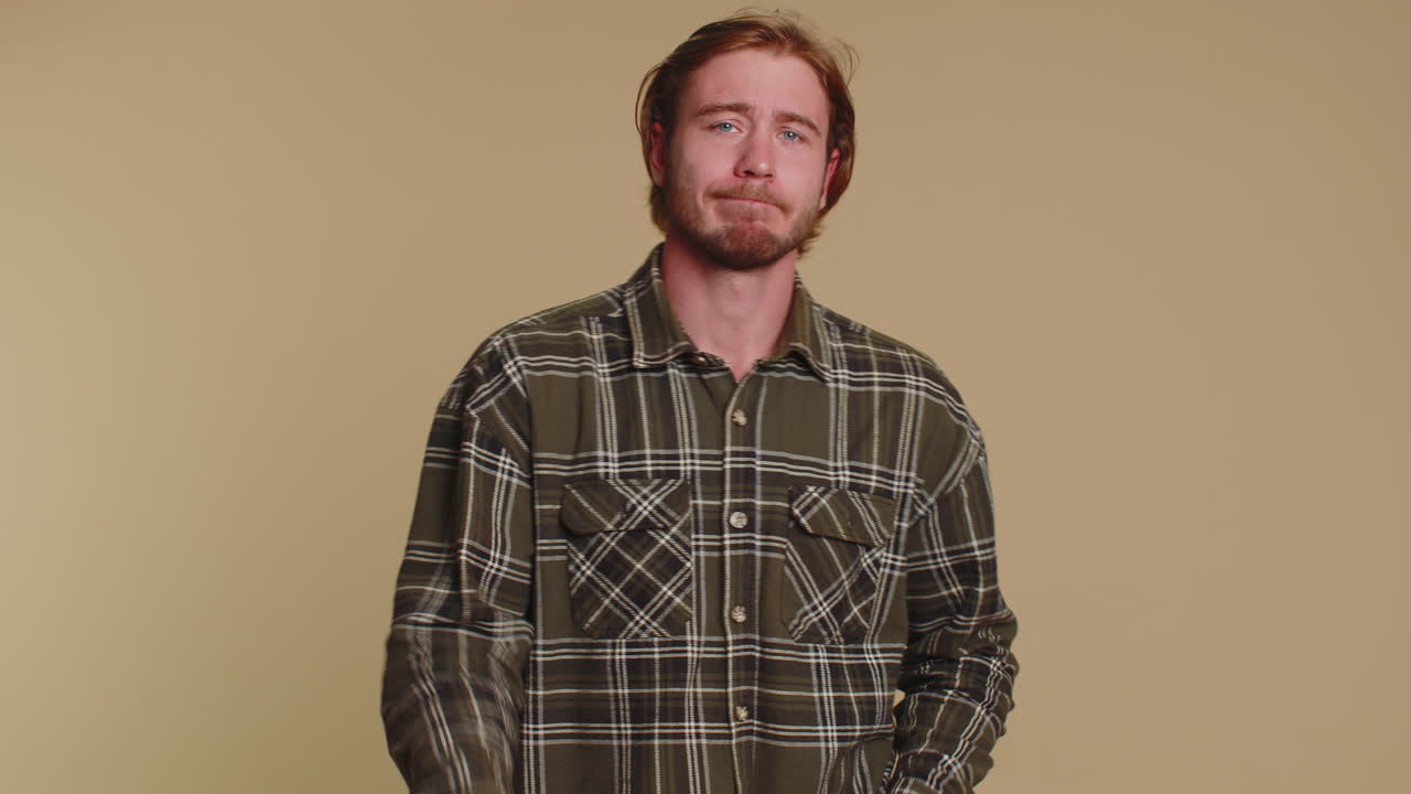 Trendy young adult man praying, looking upward and making wish, asking God for help, begging apology